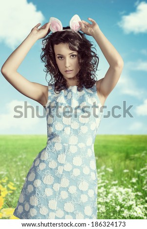 sexy young brunette girl posing in easter portrait with funny pink bunny ears and spring dress