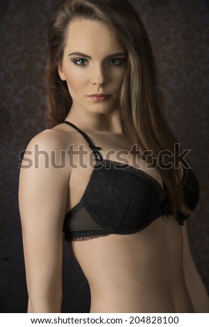 Beautiful, young, sensual woman with long, straight, brown hair, dark make up, wearing sexy, balck lingerie.