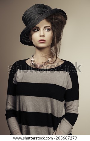 sensual girl with stylish look wearing lovely black hat, striped dress and necklace