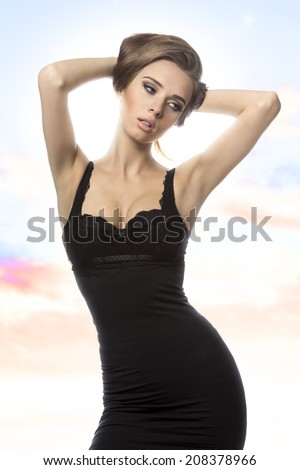 very sexy girl in fashion pose with black elegant dress and cute make-up. Vogue portrait