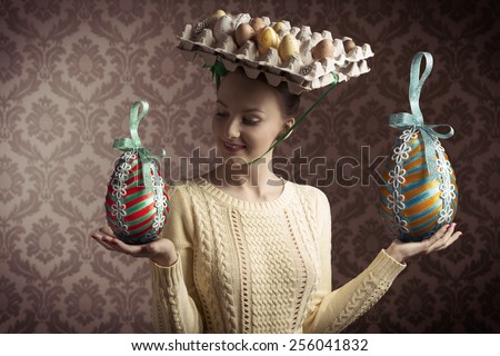 funny easter shoot of brunette female with yellow dress and bizarre hat with eggs in carton box . old fashion style
