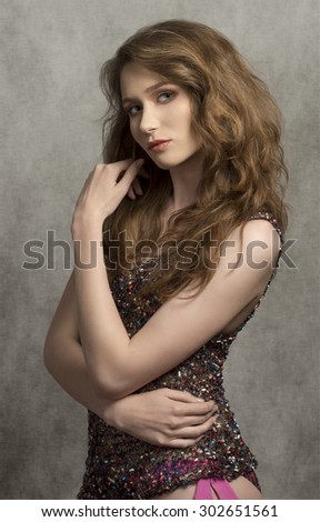portrait of cute woman with long natural hair-style wearing trendy trasparent top on bikini, posing and looking in camera