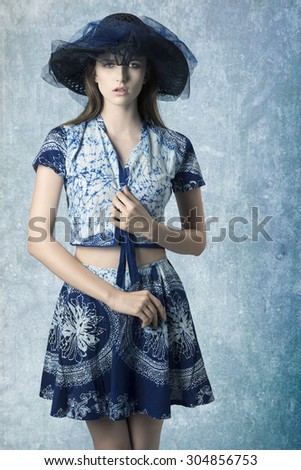 sensual woman with lovely hat and trendy summer clothes, wearing cute skirt and top and looking in camera