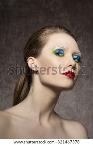 beauty portrait of charming young woman with creative artistic colorful make-up and red lipstick, charming expression