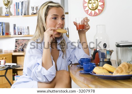 a sensual blond girl eating a toast with jam one morning during her breakfast