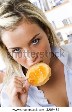 a sensual blond girl eating a toast with jam one morning during her breakfast