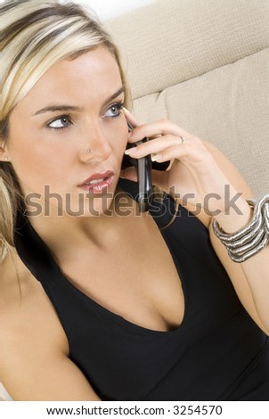 nice woman with blond hair in elegant black dress talking at the mobile telephone