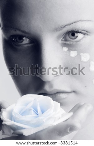 beautiful portrait in black and white of a girl looking sweetly with painted face and a rose in her hand