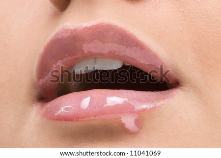 close up of a red mouth with lipstick and lip gloss dropping down