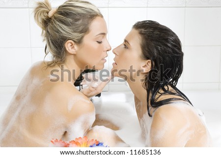 two sensual girl into a bath foam in act to kiss with sexy look