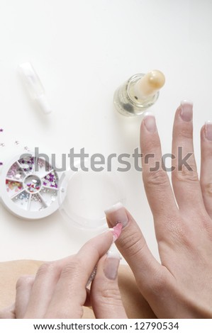 young woman painting her finger nails in a sort of nail art
