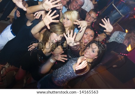 group of young people dancing and enjoying inside a night club