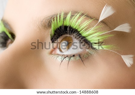 detail of an eye with green artificial eyelashes