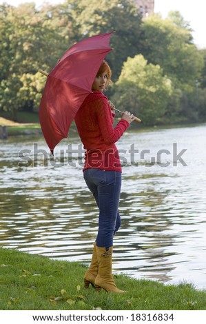 beautiful red-haired woman with red umbrella and red pullover
