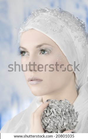 young woman in white with silver eyelashes and star on face