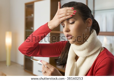 girl looking ill touching her head to check the body temperature