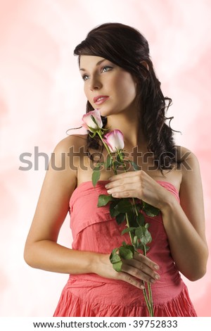 young cute brunette with pink roses and wearing a pink dress