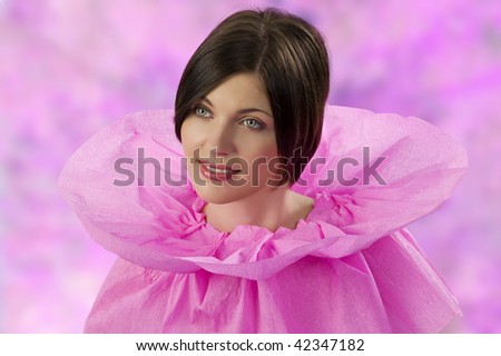 young and cute brunette in an original pink collar dress made of paper looking sweet