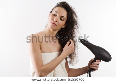 beautiful young woman with white towel and wet hair holding blow dryer
