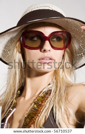 blond girl with summer hat and sunglasses posing and taking sun