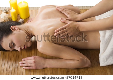 cute woman laying down on wood carpet with candle near getting an oil massage