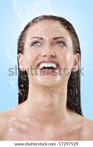 fresh portrait of a young woman with her face wet looking up and laughing