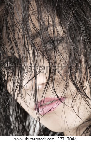 close-up in the face of nice brunette keeping her wet hair in front of her face