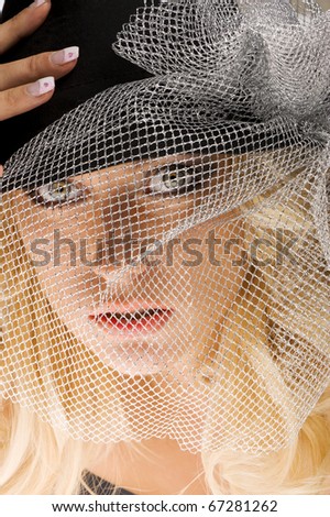 creative and nice close up beauty portrait of blond beautiful girl with silver net over her face looking in camera