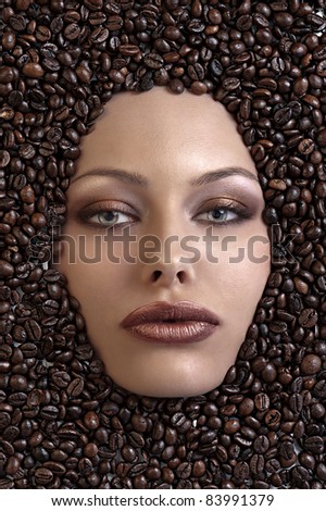 face shot of a pretty girl immersed in coffee beans