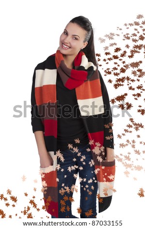 Autumn shot of a young pretty brunette wearing a dark sweater and a fall color long scarf on leaf background