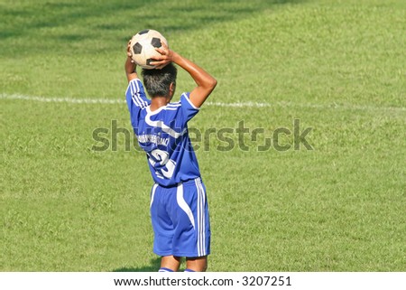 Football (soccer) player takes a throw in