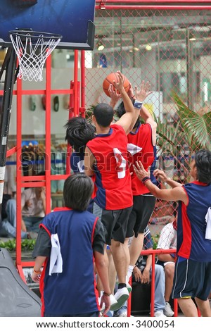 A couple of basketball players defending during a match