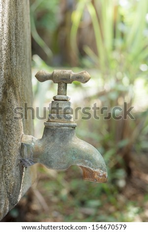 Old rusty water tap in garden.