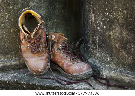 Dirty old shoes on grunge background.