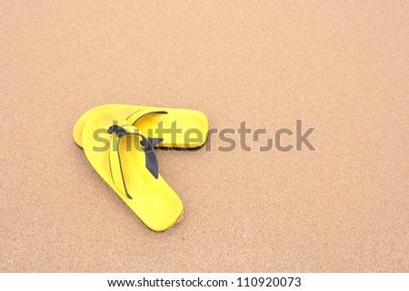 yellow slippers on the beach background