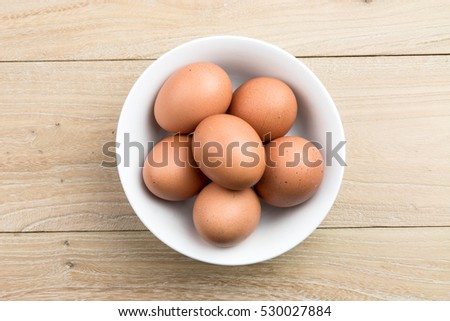 Similar – Image, Stock Photo Eggs in a bowl and baking ingredients on a kitchen table. Rustic.