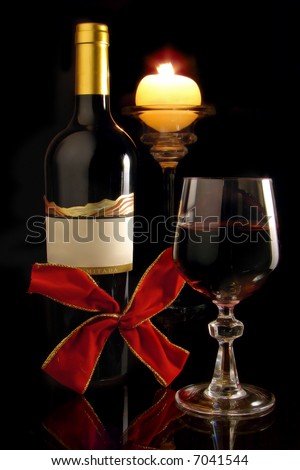 Red wine composition with wineglass, wine bottle , candle and red loop