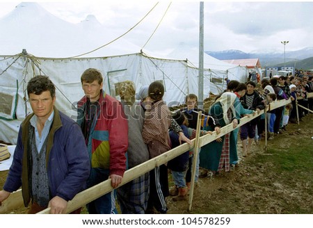 KUKES, ALBANIA, 17 APRIL 1999 -- Kosovar Albanians line up for food between rows of tents at an Italian government-operated refugee camp in northern Albania.