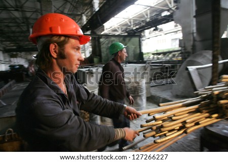 DONETSK - JULY 13: Workers move a  large amount of copper piping on the production floor at the OJSC  Artyomovsk Metals Processing Plant  in Donetsk, Ukraine, on Thursday, July 13, 2006.