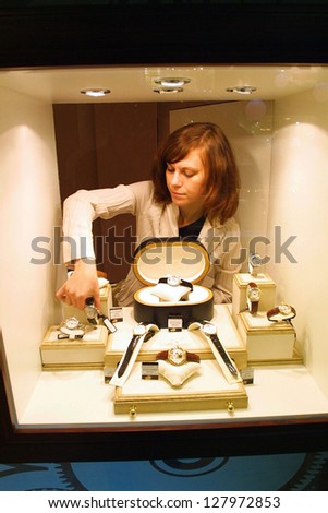 KIEV - AUGUST 16:  A sales clerk prepares luxury watches and jewelry in  a display window at an upscale mall in Kiev, Ukraine, on August 16, 2003.
