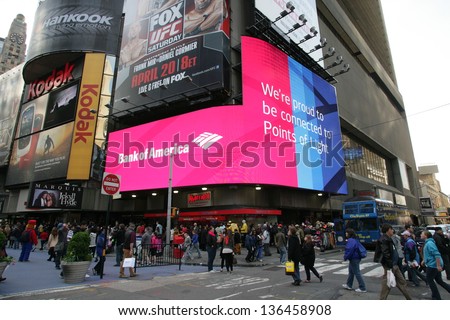 NEW YORK CITY - APRIL 19: Pedestrians walk past a giant sign advertising a Bank of America branch office  in New York City, on Friday, April 19, 2013.