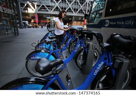 NEW YORK CITY - JULY 6: A woman takes out a Citi Bike - Operated by NYC Bike Share - in New York City on Saturday, July 6, 2013.