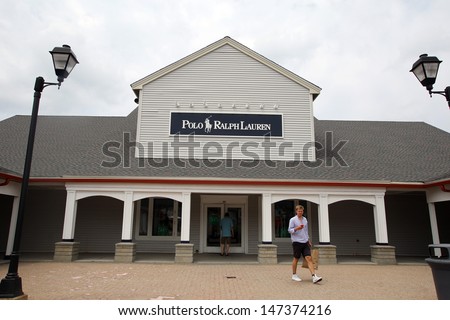 WOODBURY COMMON - JULY 9: Shoppers walk past a Ralph Lauren Polo retail clothing outlet store in Woodbury Common, New York, on Tuesday, July 9, 2013.