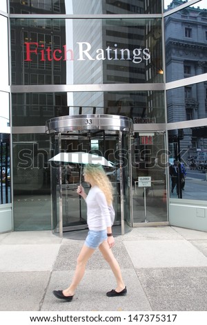 NEW YORK CITY - JULY 11: Pedestrians walk past the headquarters of Fitch Ratings in lower Manhattan on Thursday, July 11, 2013. Fitch Group is a jointly owned by Hearst Corporation and FIMALAC SA