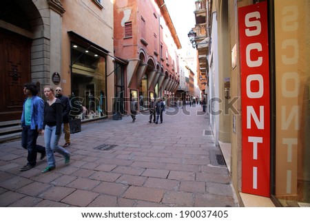 BOLOGNA, ITALY - APRIL 19, 2014:  Pedestrians walk past a sign announcing a store wide sale in Bologna, Italy, on Saturday, April 19, 2014.
