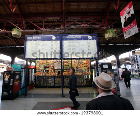 BUCHAREST, ROMANIA - MAY 15, 2014:  Pedestrians walk past the departure and arrival board at the Gare de Nord train station in Bucharest, Romania, on Thursday, May 15, 2014.