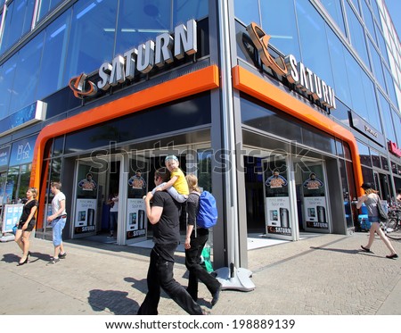 BERLIN, GERMANY - JUNE 11, 2014: Pedestrians walk past a Saturn consumer electronics store in  Berlin, Germany, on Saturday, June 11, 2014. Media-Saturn-Holding GmbH is a German corporate group.