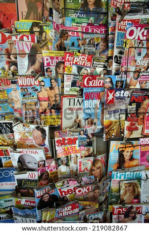GRADO, ITALY - AUG 17, 2014: A selection of local and international magazines and newspapers on display in a supermarket in Grado, Italy, on August 17, 2014.