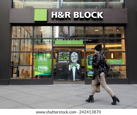 NEW YORK CITY - MONDAY, DEC. 29, 2014: Pedestrians walk past an office of H&R Block. H&R Block is a tax preparation company in the United States