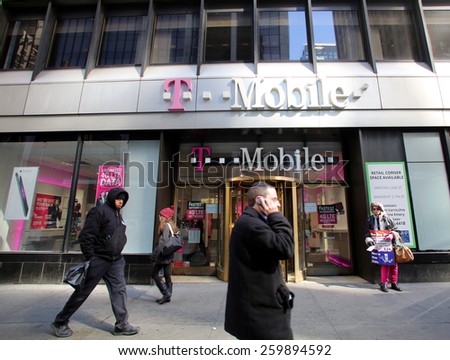 NEW YORK CITY - FEB. 25, 2015:  Pedestrians walk past a T-Mobile retail store. T-Mobile International AG is a holding company for Deutsche Telekom AG\'s  communications subsidiaries outside Germany.